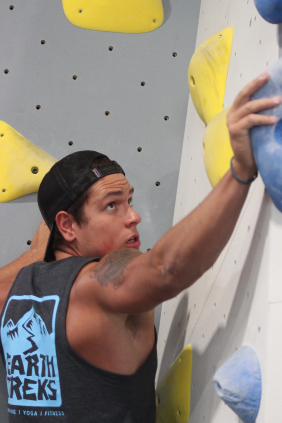 Earth Treks climbing instructor Jay Thurston plans his route up a bouldering wall. "I can't tell you how much I love the rush of adrenaline when I make it to the top," Thurston said.